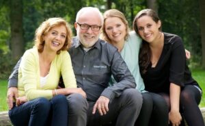 Portrait of a happy family with mother father and two daughters smiling outdoors