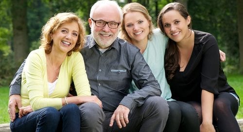 Portrait of a happy family with mother father and two daughters smiling outdoors