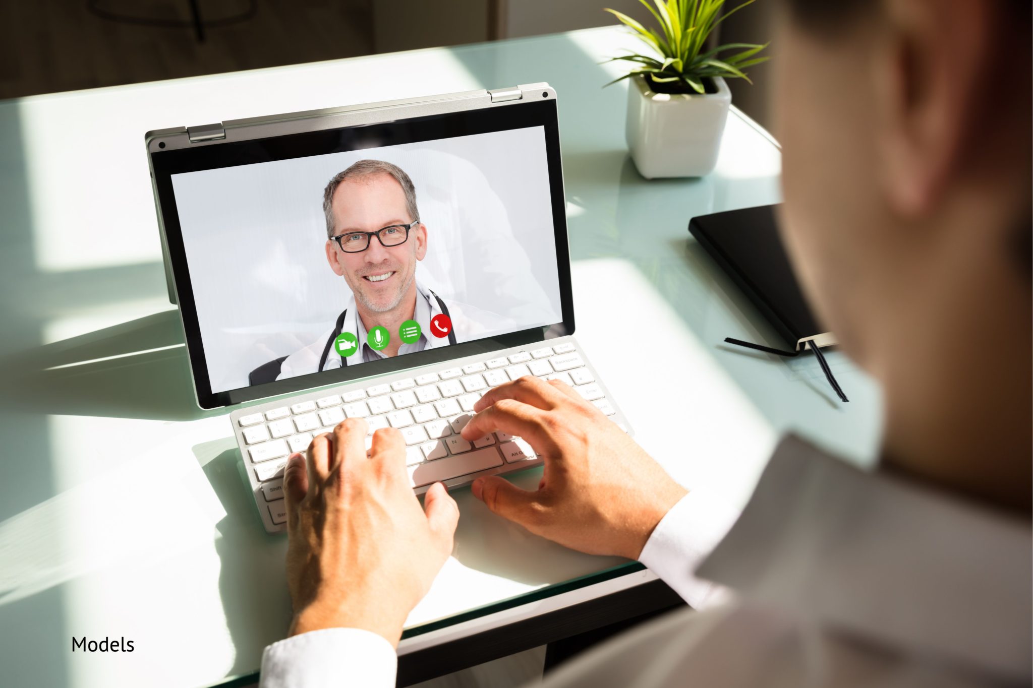 Man suing his laptop for an appointment with a doctor using telemedicine