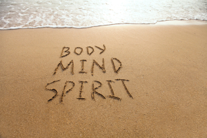 Beach with "BODY MIND SPIRIT" written in the sand